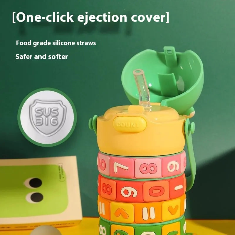 Colorful children's cup with letter and number design on a green background