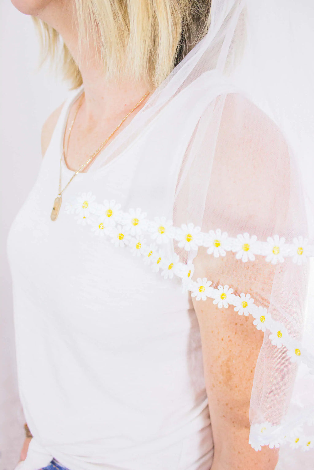 White sheer top with floral detailing worn by a person
